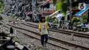 Seorang anak berjalan di bantaran rel kawasan pemukiman padat Pejompongan, Jakarta, Kamis (28/1/2020). Dalam  jangka  waktu  sepuluh  tahun  sejak  tahun  2010,  jumlah  penduduk DKI   meningkat  954  ribu  jiwa,  atau  rata-rata  sebanyak  88  ribu  jiwa  setiap tahun. (Liputan6.com/Johan Tallo)