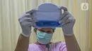 Perawat kamar bayi menunjukkan face shield (italic) di  RSIA Tambak, Jakarta, Selasa (14/4/2020). RSIA Tambak membuat face shield (italic) mandiri menggunakan plastik mika, direkatkan dengan karet atau bandana menggunakan topi bayi menghindarkan alergi pada kulit bayi. (Liputan6.com/Herman Zakharia)