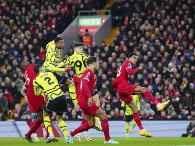 Pemain Arsenal, Gabriel Magalhaes, mencetak gol melalui tandukan kepala ke gawang Liverpool pada laga pekan ke-18 Premier League 2023/2024 di Stadion Anfield, Minggu (24/12/2023). Kedua tim bermain imbang 1-1. (AP Photo/Jon Super)