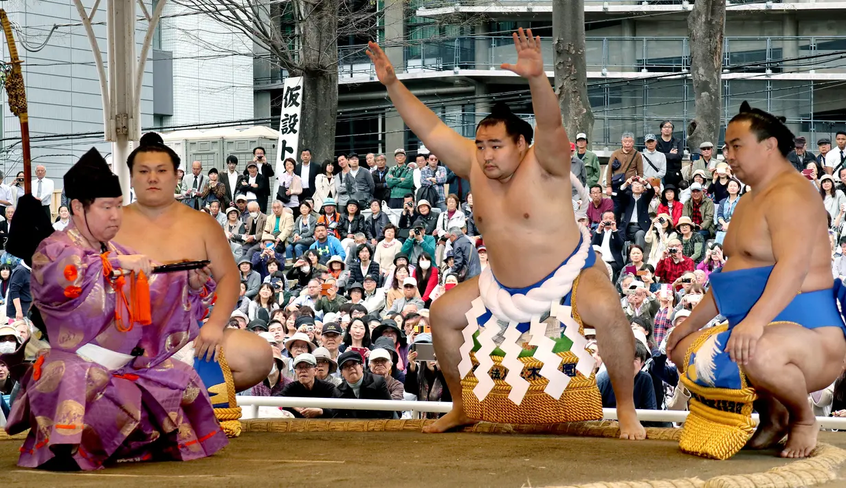 Juara gulat sumo dari Mongolia Kakuryu (kedua kanan) bersiap untuk bertanding di atas ring di Kuil Yasukuni di Tokyo, Jepang, Senin (17/4). (AP Photo / Shizuo Kambayashi)