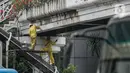 Sejumlah pekerja melakukan pengecatan ulang Penyeberangan Orang (JPO) di kawasan Thamrin, Jakarta, Kamis (28/1/2021). Pengecatan ulang tersebut dilakukan untuk merawat dan memelihara keberadaan fasilitas umum tersebut. (Liputan6.com/Faizal Fanani)