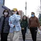 Orang-orang yang memakai masker berjalan melintasi persimpangan di Beijing, China, 13 April 2022. Shanghai bergerak untuk lebih melonggarkan lockdown di kota terbesar di China tersebut yang tampaknya terhenti. (AP Photo/Mark Schiefelbein)