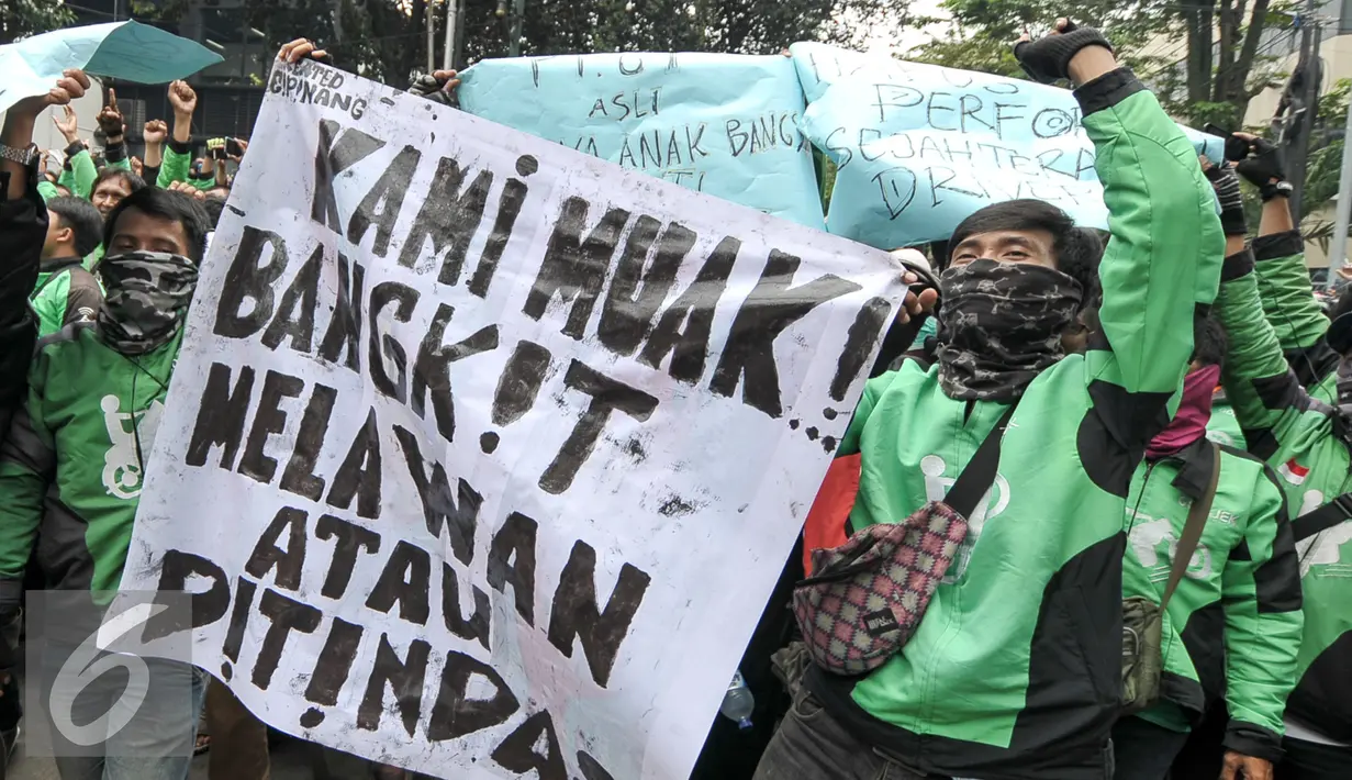 Massa driver Gojek membawa spanduk saat aksi protes ke kantor pusat mereka di Kemang, Senin (3/10). Ratusan pengemudi Gojek itu menuntut penghapusan sistem performa atau rating. (Liputan6.com/Yoppy Renato)