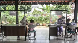 Petugas puskesmas memeriksa kesehatan anak sebelum mengikuti vaksin DT di RPTRA Citra Permata, Jakarta, Selasa (28/9/2021). Kegiatan rutin tahunan tersebut bertujuan memberikan kekebalan tubuh pada anak sekolah terhadap penyakit DT dengan kuota 150 anak per hari. (merdeka.com/Iqbal S Nugroho)