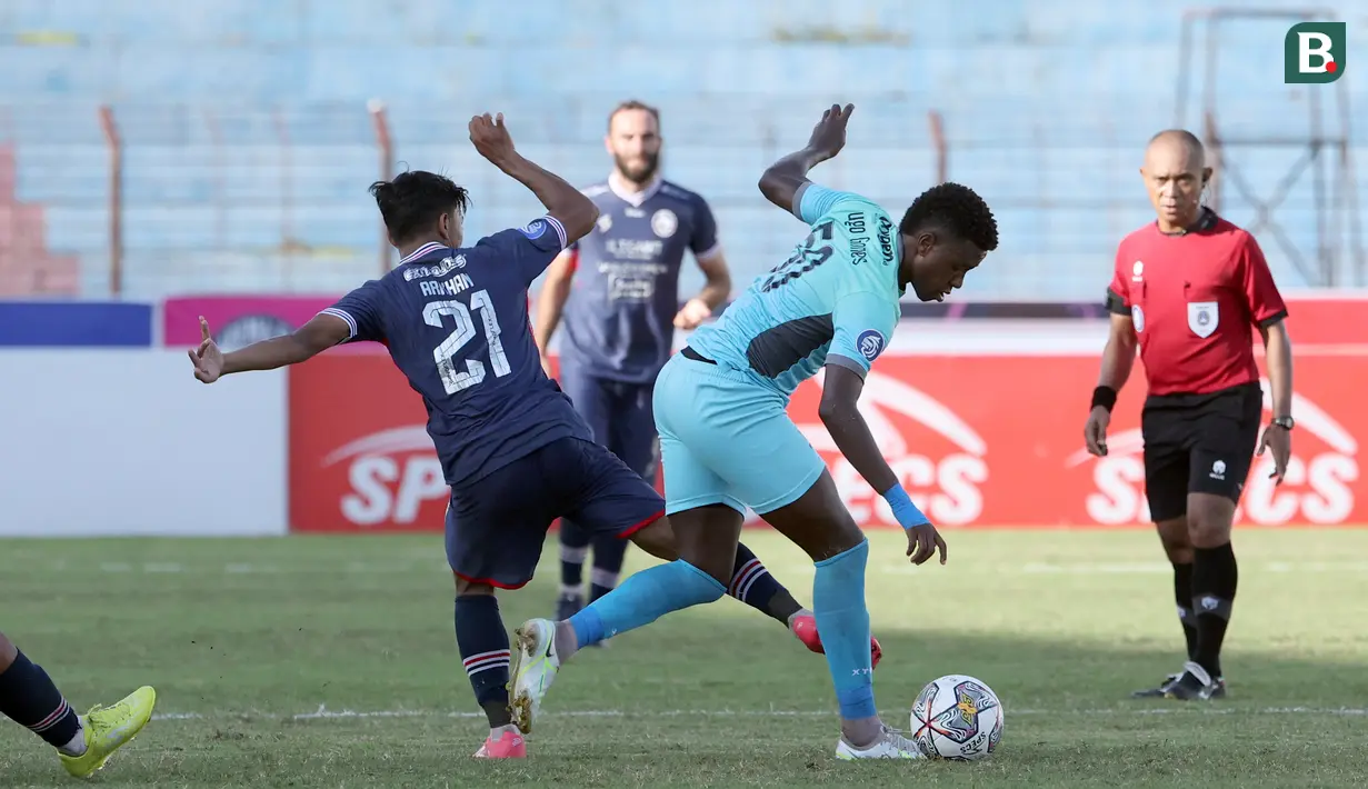 Pemain Madura United, Hugo Gomes Jaja (kanan) berebut bola dengan pemain Arema FC, Arkhan Fikri dalam laga pekan ke-16 BRI Liga 1 2022/2023 di Stadion Sultan Agung, Bantul, Yogyakarta, Selasa (20/12/2022) sore WIB. (Bola.com/Ikhwan Yanuar)