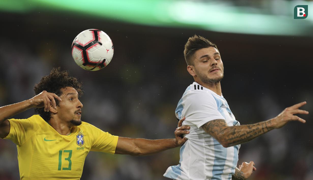Pemain Brasil, Marquinhos, duel udara dengan striker Argentina, Mauro Icardi, pada laga persahabatan di Stadion King Abdullah, Jeddah, Selasa (16/10/2018). Brasil menang 1-0 atas Argentina. (AP/STR)