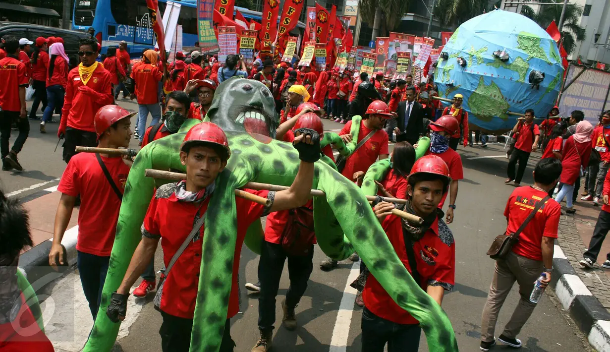 Massa buruh dari KASBI membawa gurita raksasa, bola dunia dan tikus pada peringatan May Day di Bundaran HI, Jakarta, Senin (1/5). Replika gurita itu dianggap simbol penghisap sumber daya alam yang ada di Indonesia. (Liputan6.com/Angga Yuniar)