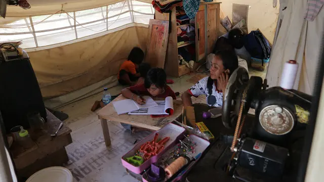 Dinar, adik, dan ibunya sedang berada di dalam tenda daruratnya di Kelurahan Balaroa, Palu Barat, Rabu (18/3/2020). (foto: Liputan6.com/Heri Susanto).