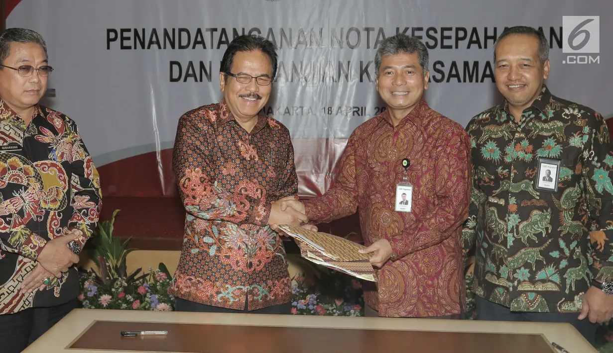 Menteri Agraria dan Tata Ruang/Badan Pertahanan Nasional (ATR/BPN) Sofyan A. Djalil (kedua kiri) bersalaman dengan Dirut PT Pegadaian (Persero) Sunarso (kedua kanan) saat penandatanganan kerjasama di Jakarta, Rabu (18/4). (Liputan6.com/Angga Yuniar)