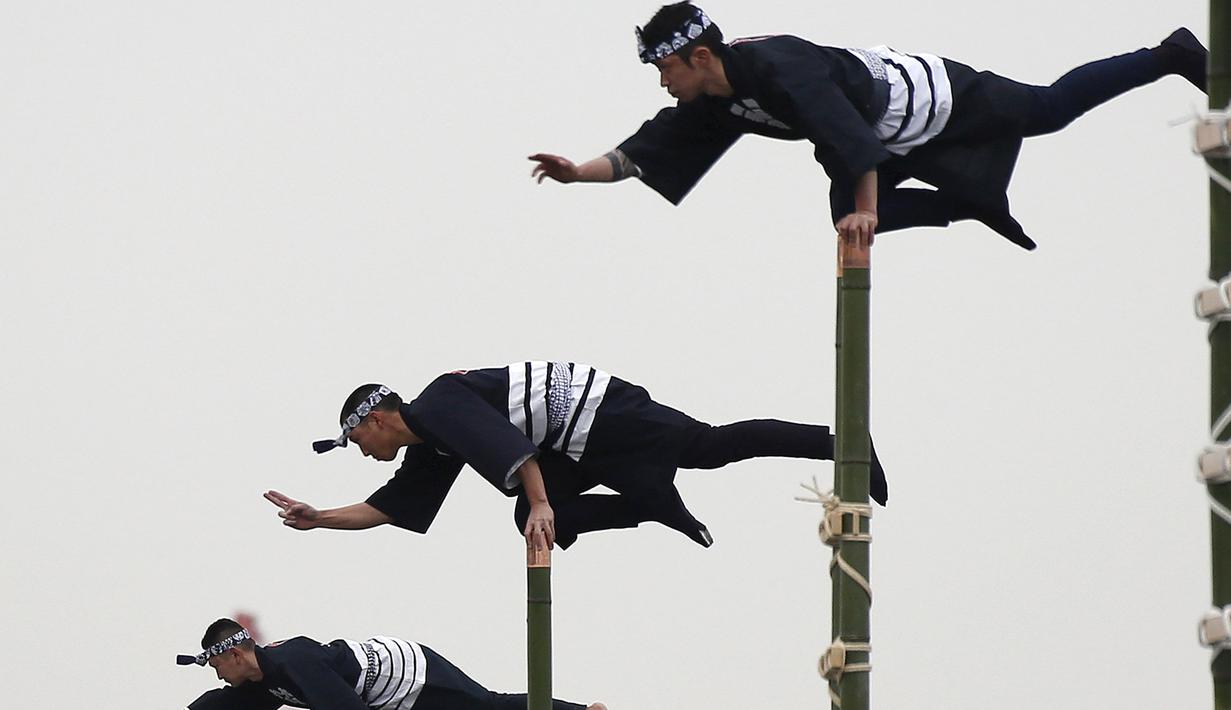 Anggota perkumpulan Edo saat menampilkan atraksi diatas ujung bambu di Tokyo, Jepang, (6/1). Atraksi ini dilakukan oleh para petugas pemadam kebakaran Tokyo.( REUTERS / Yuya Shino)