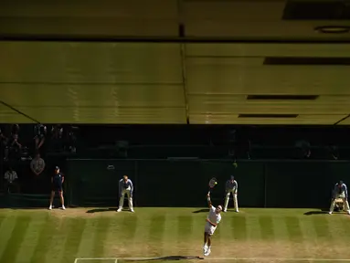 Aksi Roger Federer  saat melakukan servis melawan petenis Kroasia, Marin Cilic pada babak perempat final Tenis Wimbledon Championships 2016 di The All England Lawn Tennis Club,  Wimbledon, (6/7/2016). (AFP/Glyn Kirk)