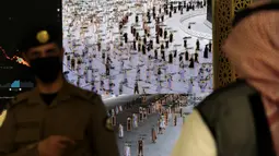 Petugas keamanan Arab Saudi menonton layar pintar yang mengidentifikasi otorisasi peziarah yang lewat untuk berpartisipasi dalam ibadah haji jelang pelaksanaan ibadah haji di pusat penerimaan jemaah al Zaidy, Mekah, Arab Saudi, Senin (12/7/2021). (AP Photo/Amr Nabil)