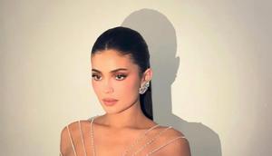 Bak golden barbie modern, Kylie Jenner tampil memukau dalam balutan gaun emas metalik rancangan Ashi Studio. [@makeupbyariel].