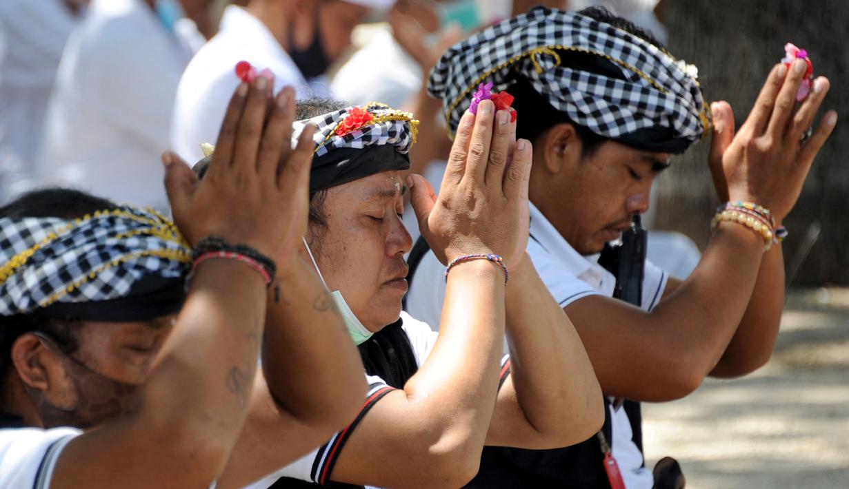 Umat Hindu berdoa saat upacara Melasti menjelang Hari Raya Nyepi Tahun Baru Saka 1943 di Pantai Kuta, Bali (11/3/2021). Ritual Melasti untuk menyucikan alam agar Hari Raya Nyepi dapat berjalan  hening serta damai. (AFP/Sonny Tumbelaka)