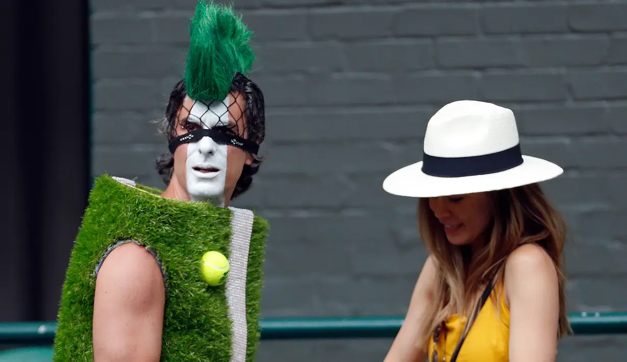 Penonton mengenakan kostum lapangan tenis tiba untuk mengambil tempat duduk selama turnamen tenis Wimbledon 2019 hari ke tujuh di The All England Tennis Club, London (2/7/2019). (AP Photo/Alastair Grant)