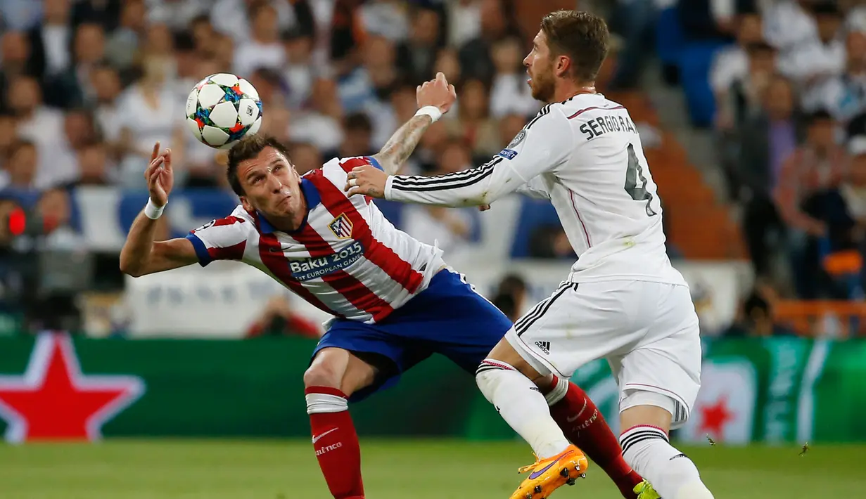 Penyerang Atletico Madrid, Mario Mandzukic (kiri) berusaha mengontrol bola dari kejaran Sergio Ramos di leg kedua 8 besar Liga Champions di Santiago Bernabeu Stadium, Kamis (23/4/2015). Real Madrid menang 1-0 atas Atletico Madrid. (Reuters/Sergio Perez)