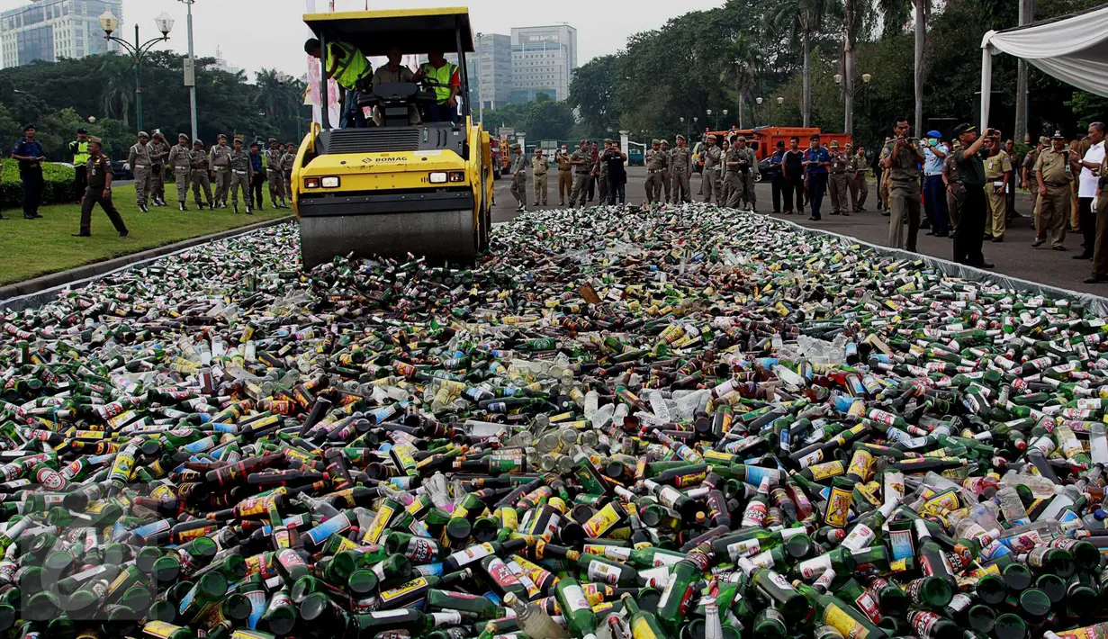 Alat berat melindas botol minuman beralkohol ilegal hasil penertiban Januari-Juni 2016, di kawasan Monas, Jakarta, Selasa (28/6). Satpol PP DKI memusnahkan 19.628 botol yang antara lain hasil penertiban di kawasan Kalijodo. (Liptan6.com/Gempur M Surya)