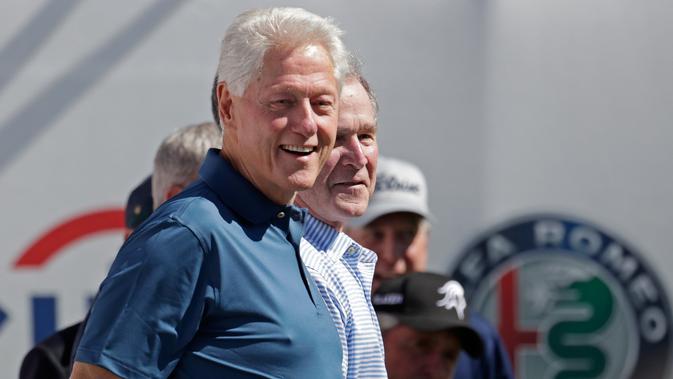 Mantan Presiden AS, Bill Clinton dan George Bush pada upacara pembukaan pertandingan golf President Cup di New Jersey, Kamis (28/9). Selain George W Bush dan Bill Clinton, turnamen juga dihadiri mantan Presiden AS, Barack Obama. (AP/Julio Cortez)