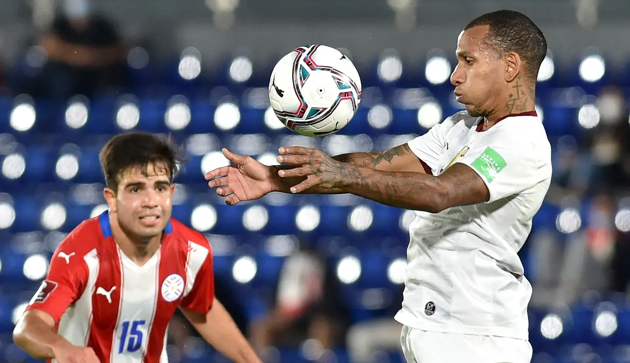 Gelandang Venezuela, Romulo Otero berebut bola dengan gelandang Paraguay, Hugo Martinez pada lanjutan Kualifikasi Piala Dunia 2022 zona Conmebol di Estadio Defensores del Chaco, Asuncion, Jumat (10/9/2021) pagi. Paraguay memetik kemenangan tipis 2-1 atas Venezuela. (NORBERTO DUARTE/AFP)