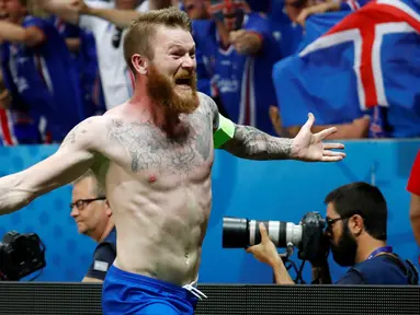 Kapten timnas Islandia, Aron Gunnarsson melakukan selebrasi dengan melepaskan jersey usai menyingkirkan Inggris di babak 16 besar Piala Eropa 2016, Selasa (28/6) dini hari. Inggris takluk 1-2 meski sempat unggul terlebih dahulu. (REUTERS/Michael Dalder)
