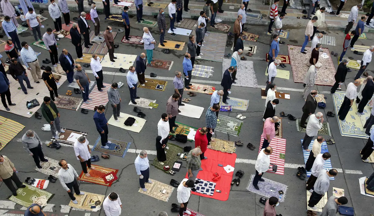 Jemaah Muslim menjaga jarak satu sama lain sebagai langkah mencegah pandemi Covid-19 saat berkumpul untuk menghadiri salat Idul Fitri di ibu kota Iran, Teheran, pada 24 Mei 2020. (Photo by - / AFP)