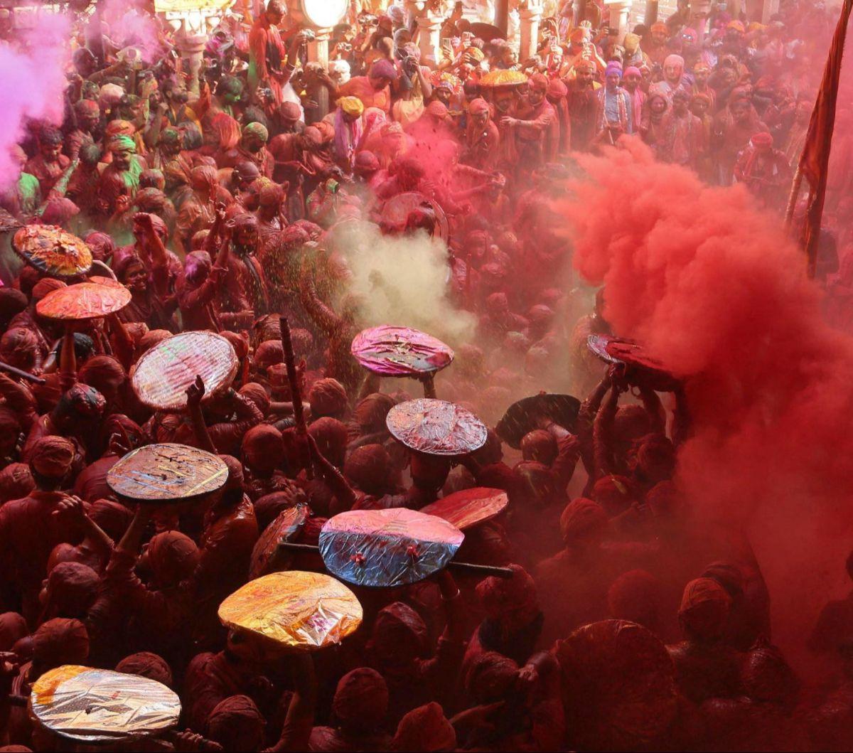 Sejumlah warga saling melempar bubuk warna-warni dalam Festival Lathmar Holi atau Festival Holi di&nbsp;sebuah kuil di Kota Barsana, Uttar Pradesh, India, pada 18 Maret 2024. Festival Holi yang identik dengan perang bubuk warna-warni kembali digelar di be