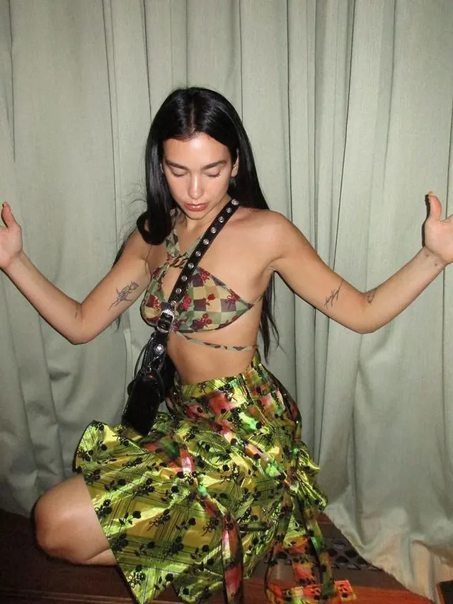 Potret Dua Lipa dengan Rok Unik Tampilkan Look Punk di Era 90an