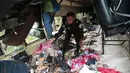 Seorang petugas polisi mengumpulkan sepatu dari bus yang jatuh di jalan raya Pan-Amerika di Condega, Nikaragua (28/7/2022). Polisi melaporkan pada Kamis (28/7) Kecelakaan lalu lintas yang terjadi di jalan raya di Nikaragua utara menyebabkan 16 orang tewas, termasuk 13 orang Venezuela, mungkin migran, selain 47 terluka. (AFP Photo/Oswaldo Rivas)