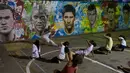 Anak-anak sedang berlatih seni bela diri khas Brasil Capoeira di dekat tembok lukisan wajah pemain top dunia, Brasil, Rabu (21/05/2014) (AFP PHOTO/Yasuyoshi CHIBA).