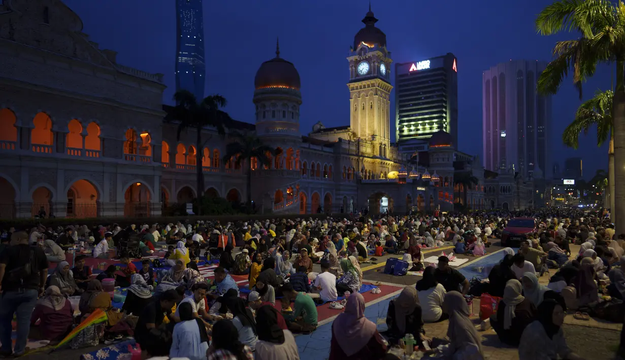 Umat muslim berbuka puasa di bulan suci Ramadhan 1444 Hijriahg di Dataran Merdeka (Lapangan Merdeka) di Kuala Lumpur, Malaysia, Sabtu, 1 April 2023. (AP Photo/Vincent Thian)