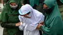 Polisi syariat membawa terpidana kasus zina untuk menjalani hukuman cambuk di halaman Masjid Al-Munawarah, Kota Jantho, Aceh Besar,  Jumat (9/4/2020). Pasangan terpidana yang terbukti melanggar Syariat Islam dalam kasus zina itu masing masing menjalani sebanyak 100 cambuk. (CHAIDEER MAHYUDDIN/AFP)