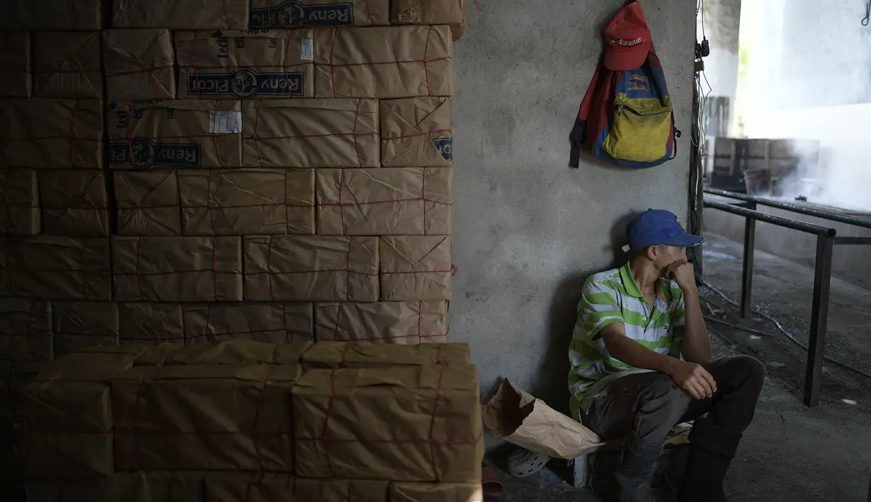 Pekerja tebu beristirahat di dekat panelas yang dikemas di panelero trapiche, Venezuela 21/9/2020). Jus tebu dibuat menjadi gula tebu utuh yang tidak dimurnikan yang dikenal sebagai panela, yaitu sukrosa berbentuk padat yang berasal dari perebusan dan penguapan sari tebu. (AP Photo/Matias Delacroix)