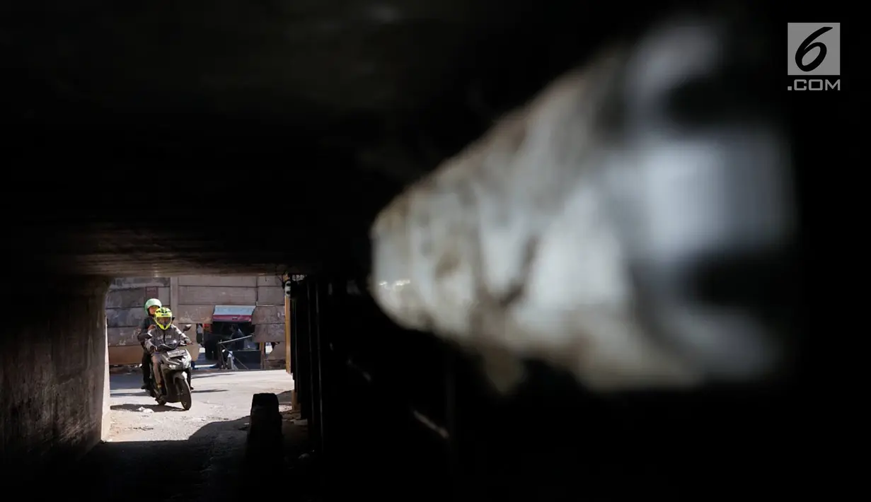 Pengendara motor melintasi terowongan di bawah Jalan Tol Jagorawi, kawasan Kampung Rambutan, Jakarta, Rabu (21/8/2019). Meskipun sempit dan gelap, namun terowongan itu menjadi akses alternatif pengguna jalan untuk menyeberangi Jalan Tol Jagorawi di kawasan tersebut. (Liputan6.com/Immanuel Antonius)