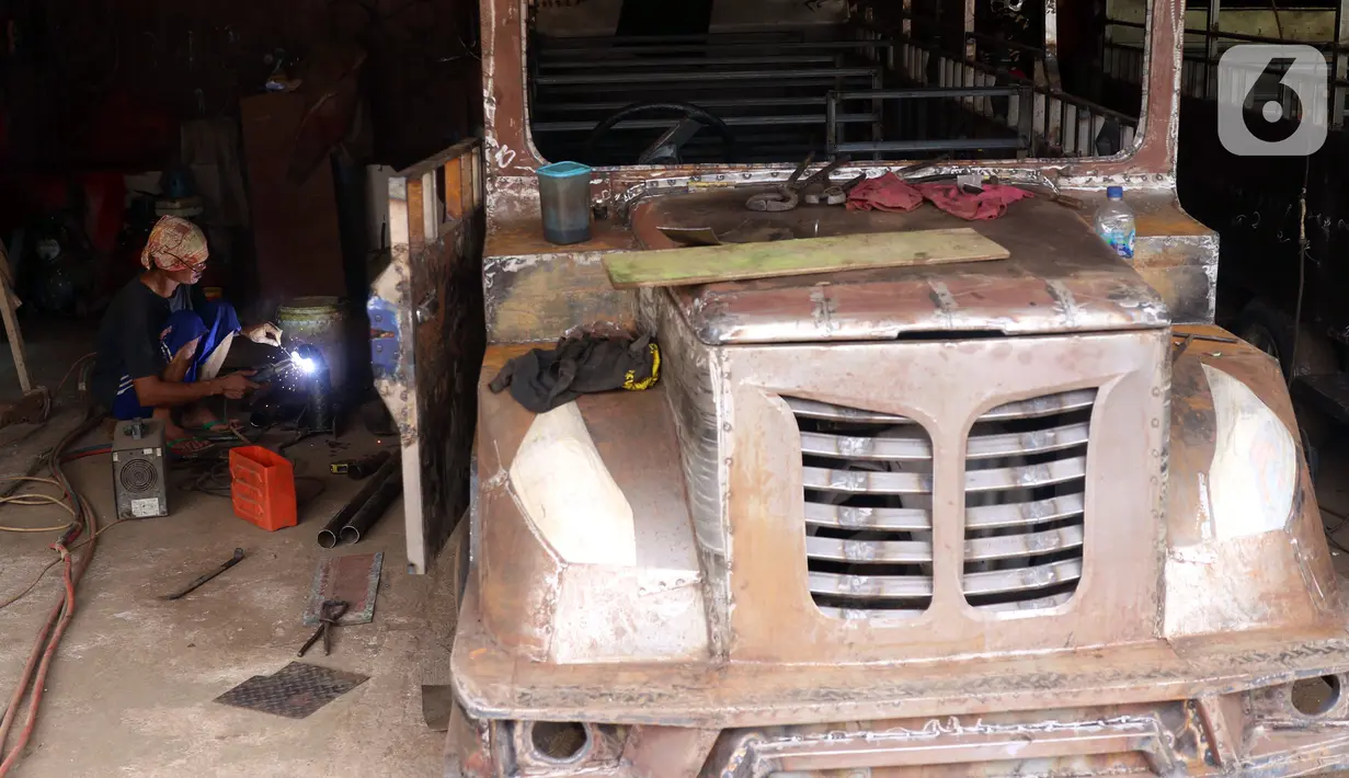 Pekerja menyelesaikan pembuatan odong-odong di Tangerang Selatan, Banten, Rabu (23/2/2022). Odong-odong yang dibuat dalam waktu sekitar satu bulan tersebut dijual dengan harga Rp 65 juta sampai Rp 100 juta, tergantung dari bahan pembuatan. (Liputan6.com/Angga Yuniar)