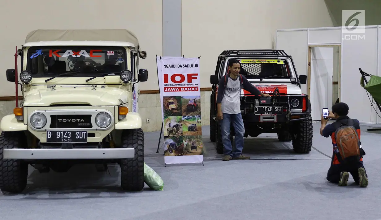 Pengunjung berpose di samping mobil dalam pameran bertajuk Deep & Extreme Indonesia 2018 di JCC Senayan, Jakarta, Jumat (9/3). Pameran ini digelar dari 8-11 Maret 2018. (Liputan6.com/Immanuel Antonius)