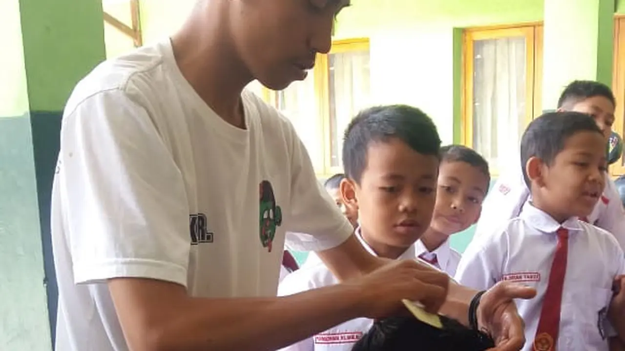 Para siswa SDN 1 Bayongbong, Garut nampak asik saat pelaksanaan cukur rambut gratis saat Hari Anak Sedunia