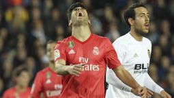 Gelandang Real Madrid, Marco Asensio, tampak kecewa usai gagal mencetak gol ke gawang Valencia pada laga La Liga 2019 di Stadion Mestalla, Rabu (3/4). Valencia menang 2-1 atas Real Madrid. (AP/Alberto Saiz)
