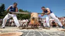 Peserta menggergaji batang pohon dengan "tronza", gergaji tradisional daerah Basque, pada hari ketiga festival San Fermin di Pamplona, Spanyol, Senin (8/7/2019). Festival San Fermin menghadirkan beberapa olahraga pedesaan Basque seperti menggergaji dan memotong pohon dengan kapak. (JAIME REINA/AFP)