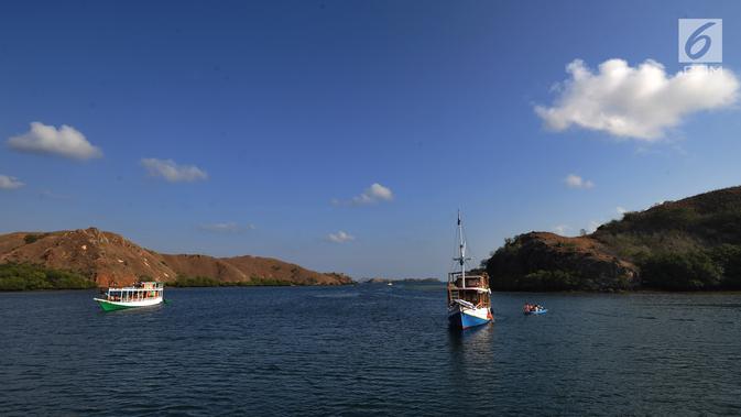Kapal-kapal wisatawan mengarungi sebuah teluk di Pulau Rinca, Taman Nasional Komodo, NTT, Minggu (14/10). Secara administratif, Pulau Rinca termasuk wilayah Kecamatan Komodo, Kabupaten Manggarai Barat, Provinsi NTT. (Merdeka.com/Arie basuki)