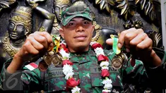 Letnan Dua Inf Poltak Siahaan menunjukkan medali yang diraihnya di ajang Australian Army Skill and Arms Meeting (AASAM) 2016, Banten, Senin (23/5/2016). TNI AD menjadi juara umum dengan meraih 23 medali emas. (Liputan6.com/Helmi Fithriansyah)