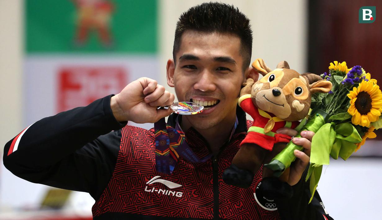 Atlet Wushu Indonesia, Harris Horatius melakukan selebrasi usai meraih medali perak dalam cabang olahraga Wushu nomor Taolu Nan Quan Putra SEA Games 2021 di Cau Giay Gymnasium, Hanoi, Sabtu (14/5/2022). Harris berada di posisi kedua dengan poin 9,7. (Bola.com/Ikhwan Yanuar)