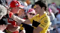 Pembalap tim Renault Carlos Sainz Jr. memberikan tanda tangan kepada fans sesaat sebelum latihan bebas Formula 1 (F1) GP Australia di Melbourne, Jumat (23/3). Balapan F1 GP Australia 2018 sendiri akan bergulir pada Minggu, 25 Maret besok (AP/Rick Rycroft)