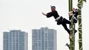 Para pemadam kebakaran berpakaian tradisonal menunjukan keahliannya menyeimbangkan tubuh di atas puncak bambu saat perayaan Tahun Baru di Tokyo, Jepang, Jumat (6/1). Atraksi ini mereka persembahkan untuk perayaan Tahun Baru. (Toshifumi KITAMURA/AFP)