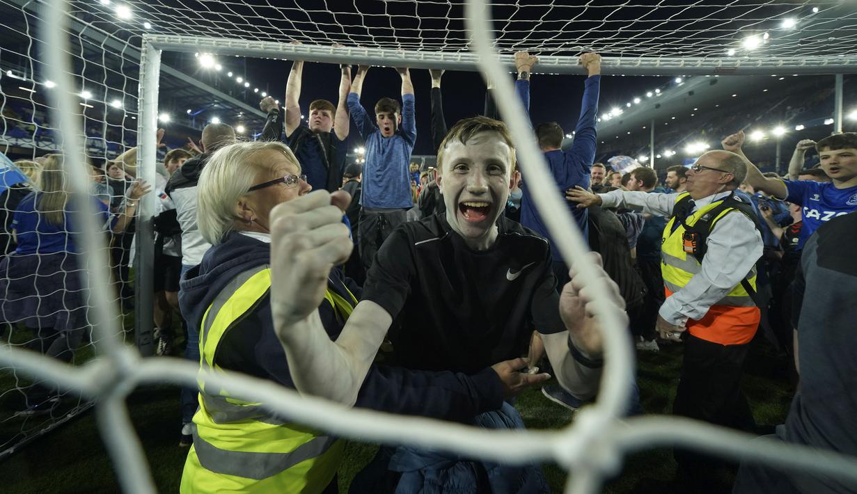 Suporter Everton menyerbu lapangan untuk merayakan akhir pertandingan Liga Inggris antara Everton dan Crystal Palace di Goodison Park di Liverpool, Inggris, 19 Mei 2022. Everton berhasil menang lewat come back dramatis 3-2 dan keluar dari zona degradasi Liga Inggris. (AP/Jon Super)