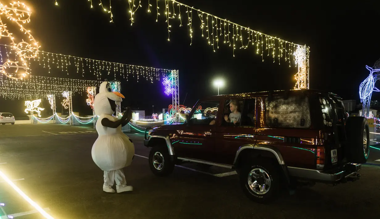 <p>Pengunjung naik kendaraan mereka ke "The Candy Cane Lane Holiday Light Drive Through Experience" yang menampilkan hanya kurang dari satu kilometer lampu Natal dan dekorasi di atap Pusat Perbelanjaan Pavillion di Durban, Afrika Selatan (14/12/2021). (AFP/Rajesh Jayantilal)</p>