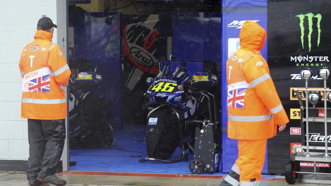 Motor Valentino Rossi dari tim Movistar Yamaha masih berada di paddock karena hujan deras yang mengguyur Sirkuit Silverstone jelang balapan MotoGP Inggris, Minggu (26/8/2018). Balapan dibatalkan karena cuaca buruk. (AP Photo/Rui Vieira)