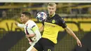 Striker Borussia Dortmund, Erling Braut Haaland, berebut bola dengan bek Paris Saint-Germain, Thiago Silva, pada leg pertama 16 besar Liga Champions di Signal Iduna Park, Dortmund, Rabu (19/2) dini hari WIB. Dortmund menang 2-1 atas PSG.(AFP/Ina Fassbender)