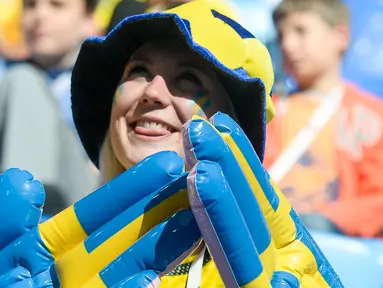 Suporter wanita Swedia tersenyum menunggu pertandingan antara Swedia melawan Swiss pada babak 16 besar Piala Dunia 2018 di Stadion Saint Petersburg, Rusia (3/7). Swedia berhasil mengalahkan Swiss 1-0 dan melaju ke babak 8 Besar. (AFP Photo/Olga Maltseva)