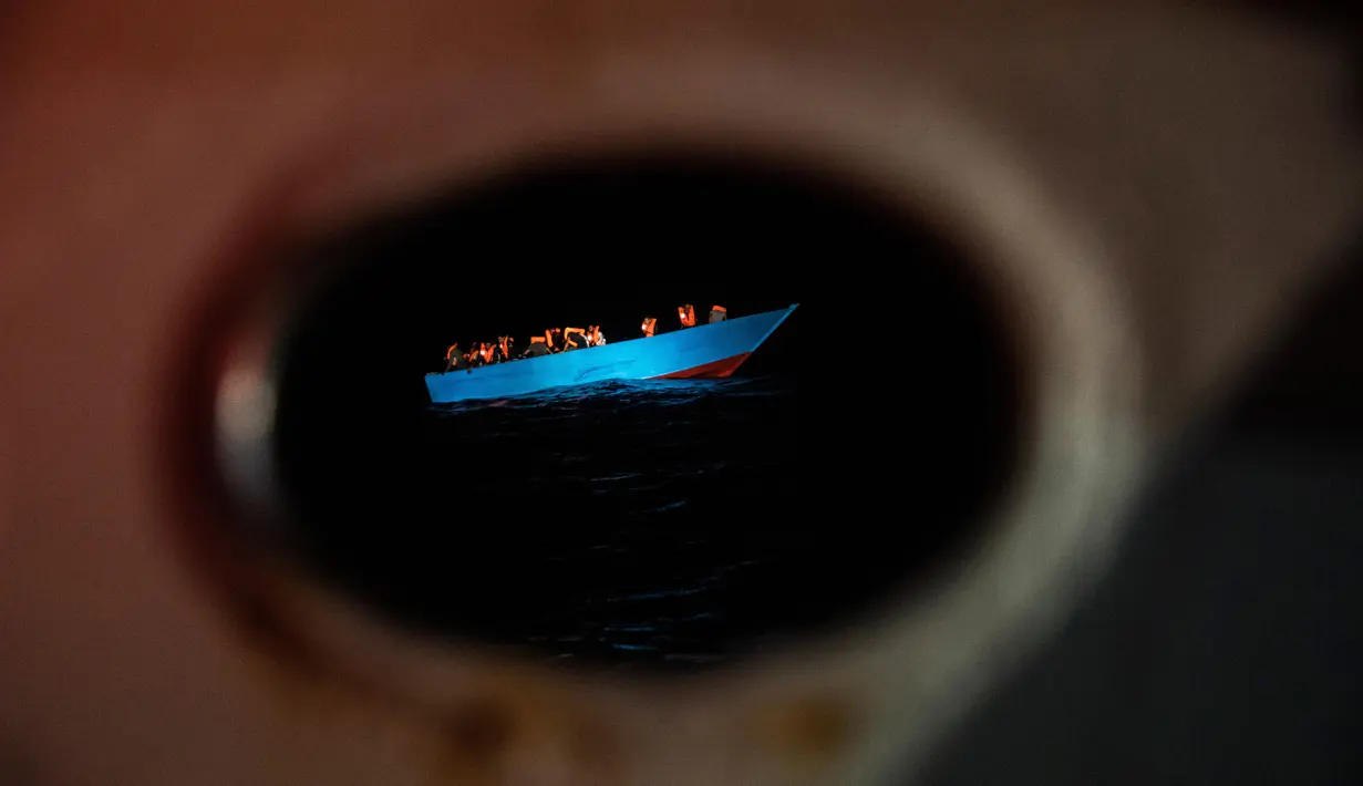 Migran, dari Mesir, Maroko, Somalia, dan Sierra Leone menunggu untuk dibantu oleh LSM Spanyol Open Arms, setelah lebih dari 20 jam berada di laut ketika melarikan diri dari Libya dengan perahu kayu di perairan internasional, di laut Mediterania Tengah, 8 September 2020. (AP Photo/Santi Palacios)
