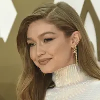 Gigi Hadid tersenyum saat tiba menghadiri CMA Awards tahunan ke-53 di Bridgestone Arena di Nashville, Tennessee (13/11/2019). Model berusia 24 tahun ini tampil memukau dalam balutan gaun putih. (AP Photo/Evan Agostini)